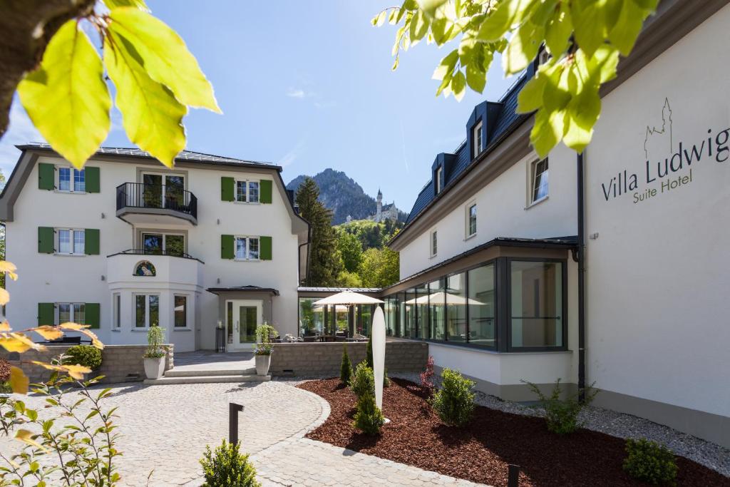 
a large white house with a large window at Hotel Villa Ludwig in Hohenschwangau
