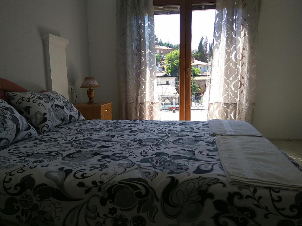 Schlafzimmer mit einem großen Bett und einem Fenster in der Unterkunft Ivanoski Studios and Guest Rooms in Ohrid