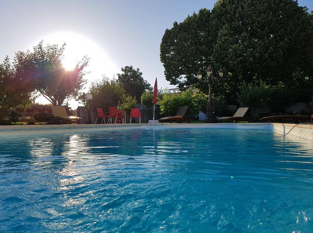 una gran piscina con el sol en el fondo en Solar Quinta de São Carlos, en Viseu