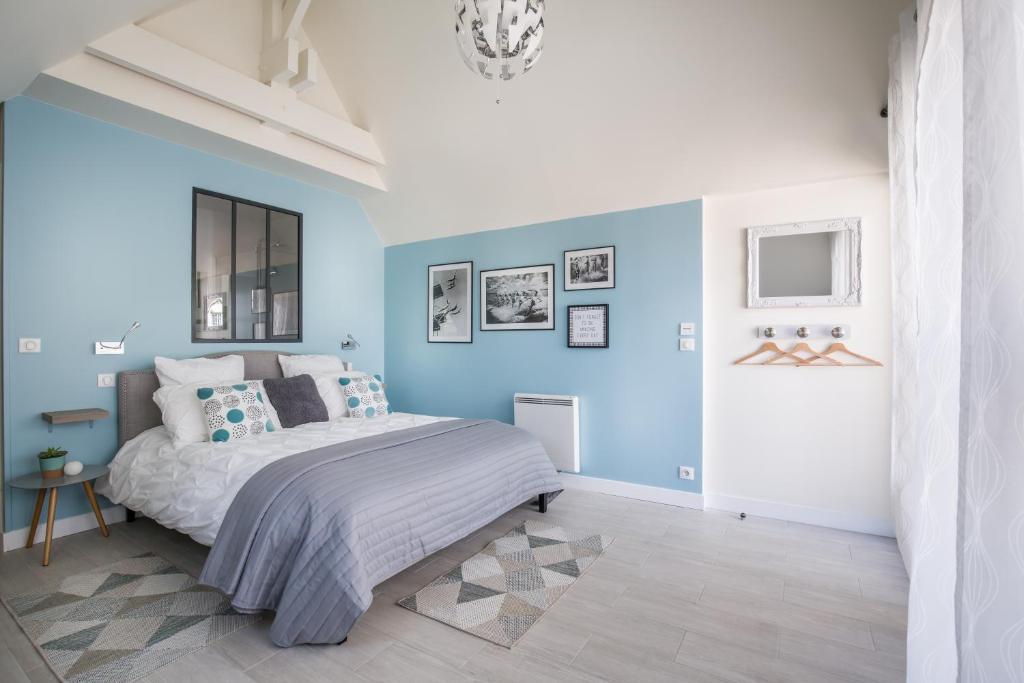 a bedroom with blue walls and a large bed at Chambre d'hôtes La Bourdonnaise in Bourdonné