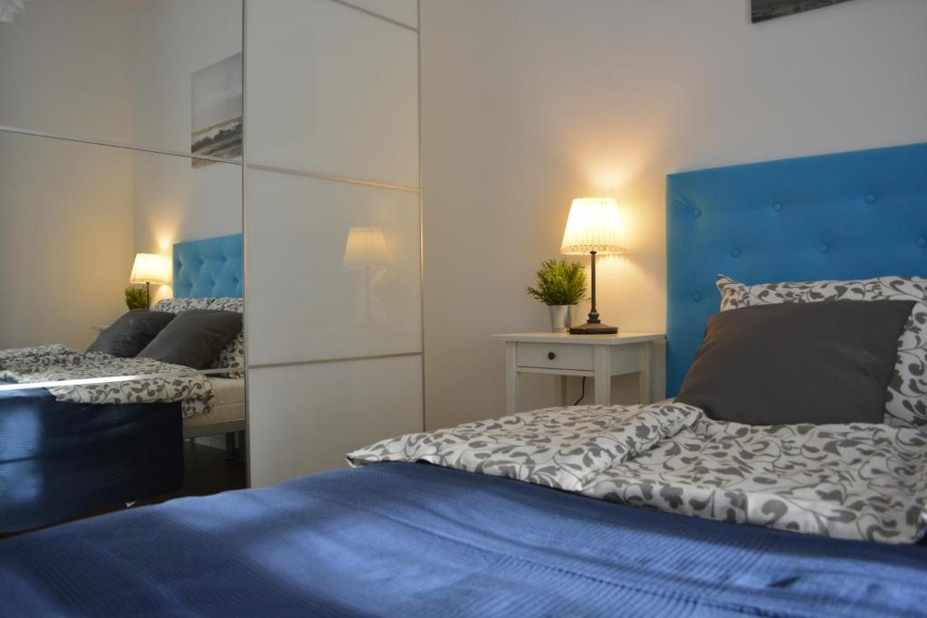 1 dormitorio con 2 camas y cabecero azul en MARINA Park Apartment, en Świnoujście