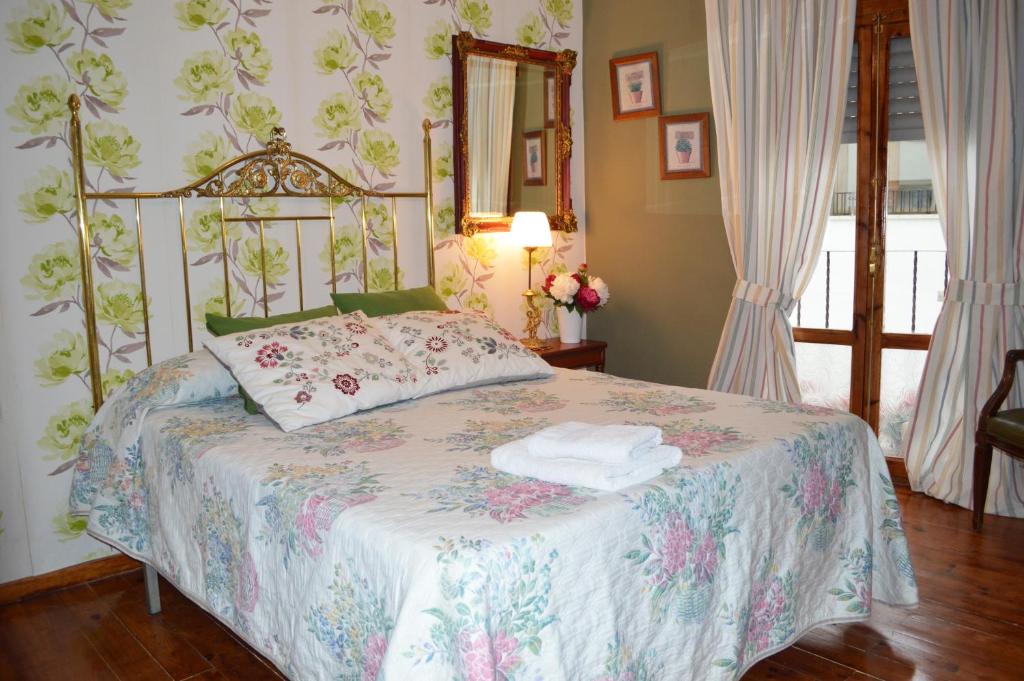a bedroom with a bed with a floral bedspread at Casa Escosa in Albalate del Arzobispo