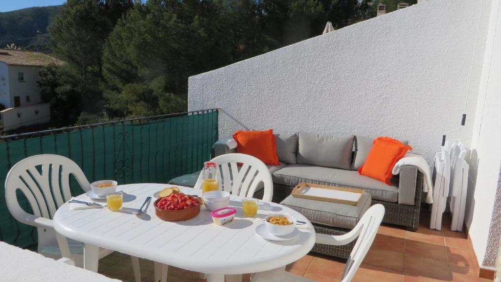 a white table and chairs on a balcony with a couch at *Casa Anna L'Atzubia in Adsubia