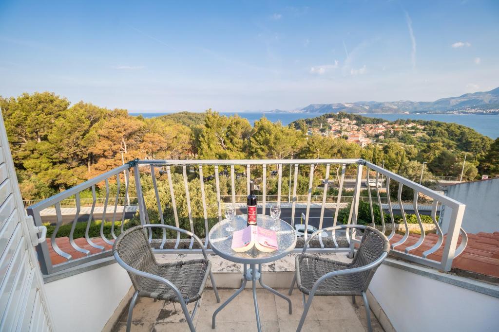 - une table avec une bouteille de vin sur le balcon dans l'établissement Pansion Lovac, à Cavtat