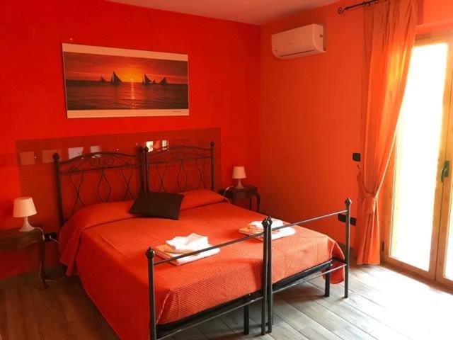 1 dormitorio rojo con 1 cama en una habitación en Sopra le Laure B&B, en Laureana di Borrello