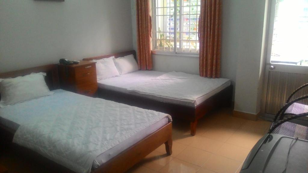 2 camas en una habitación pequeña con ventana en Hien Luong Hotel, en Nha Trang