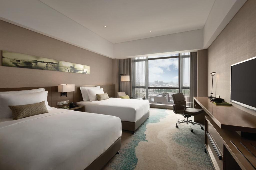 Postel nebo postele na pokoji v ubytování Wyndham JinJiang Hotel