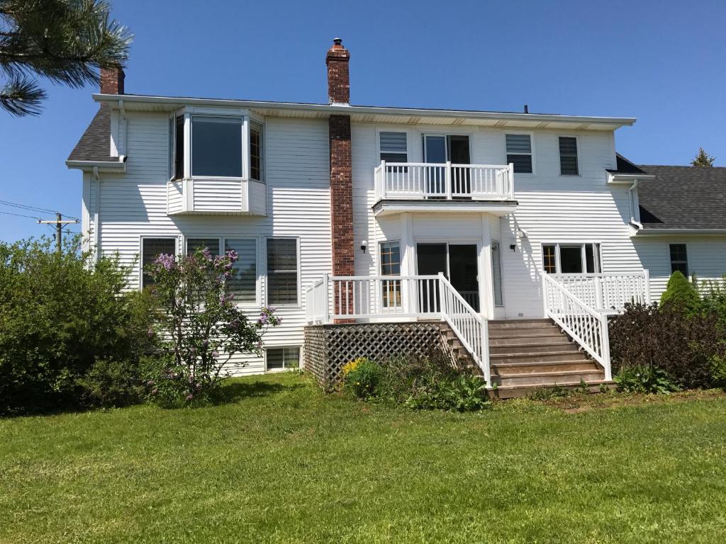 a large white house with a porch and stairs at Seaview White House in Stratford