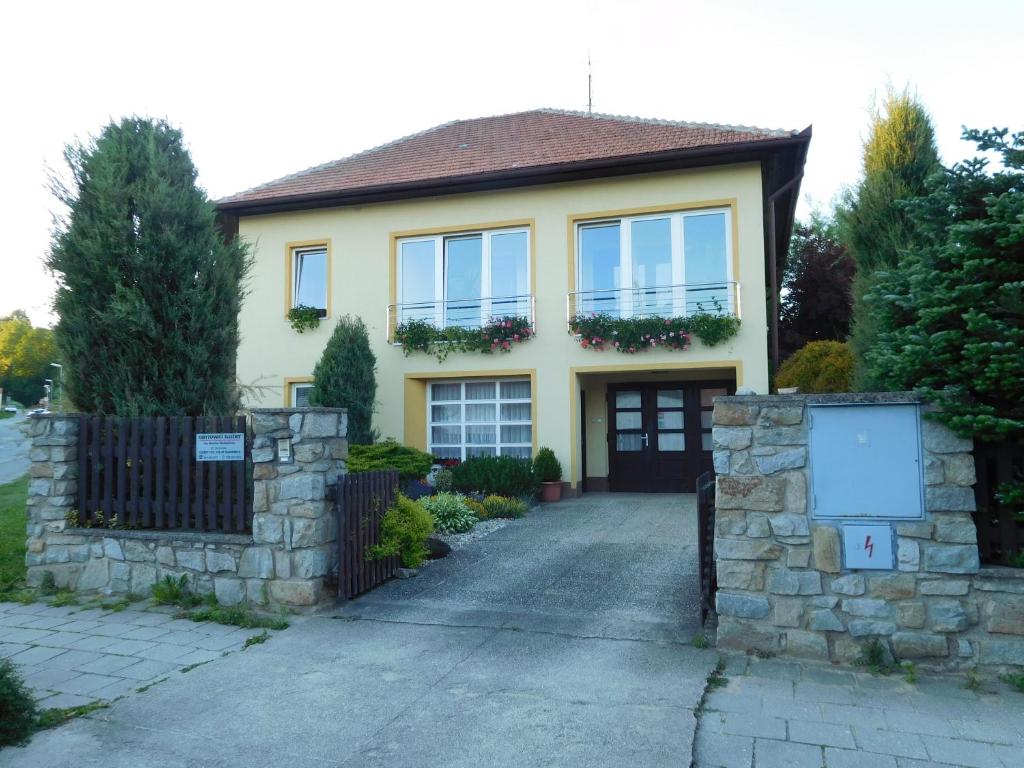 ein gelbes Haus mit einem Tor und einer Einfahrt in der Unterkunft Apartman Springerovi in Slavonice