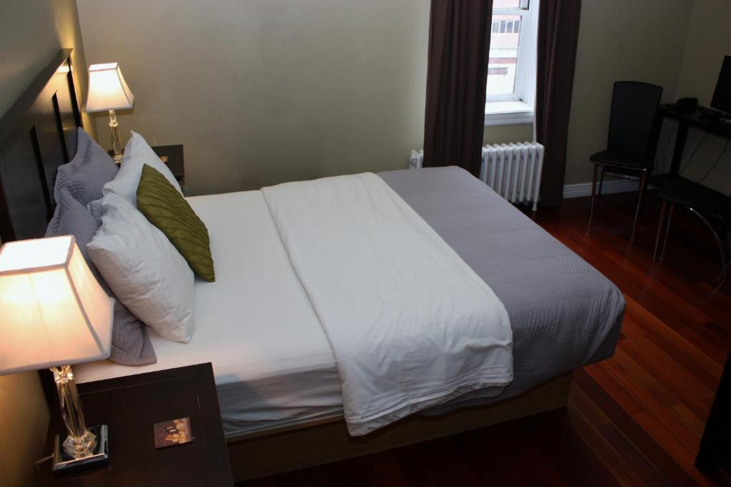 - une chambre dotée d'un grand lit avec des draps et des oreillers blancs dans l'établissement The Duckworth Inn, à Saint-Jean