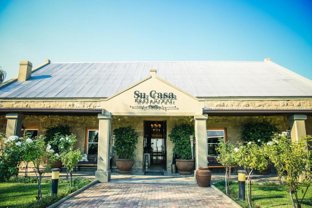 a building with a sign that reads six casa restaurant at Surval Boutique Olive Estate in Oudtshoorn