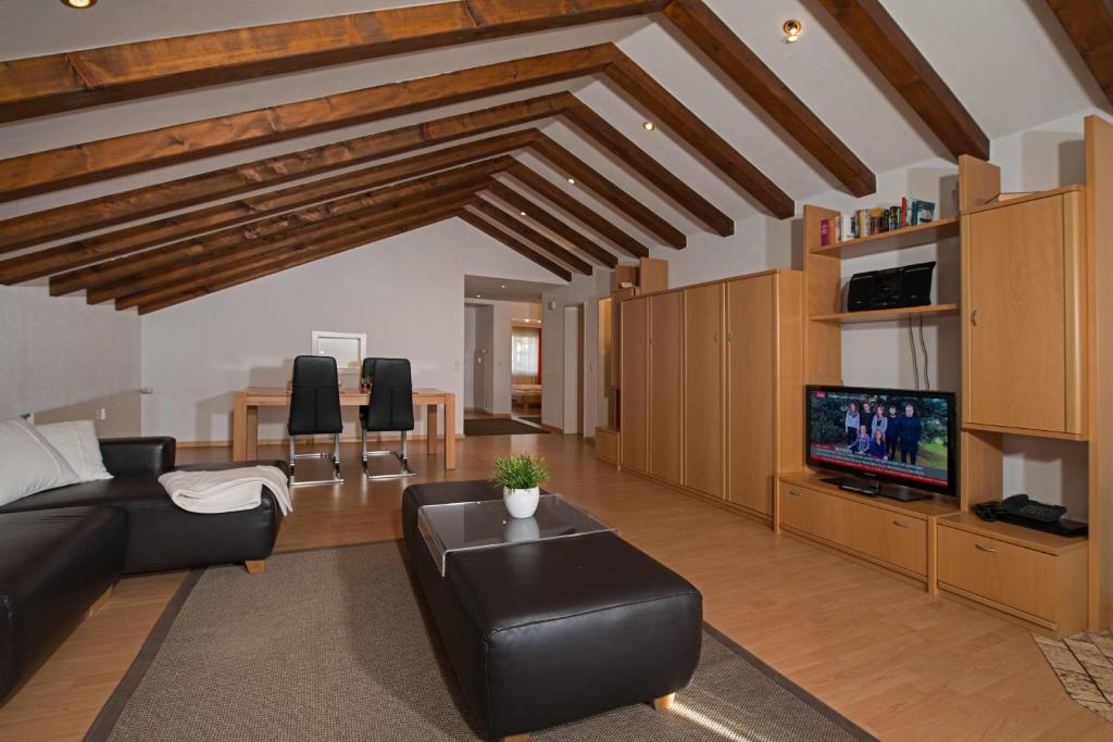 een woonkamer met een bank en een tv bij Haus Granit in Zermatt