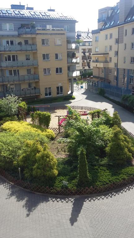 un parque con árboles y arbustos frente a los edificios en Kabaty Point, en Varsovia