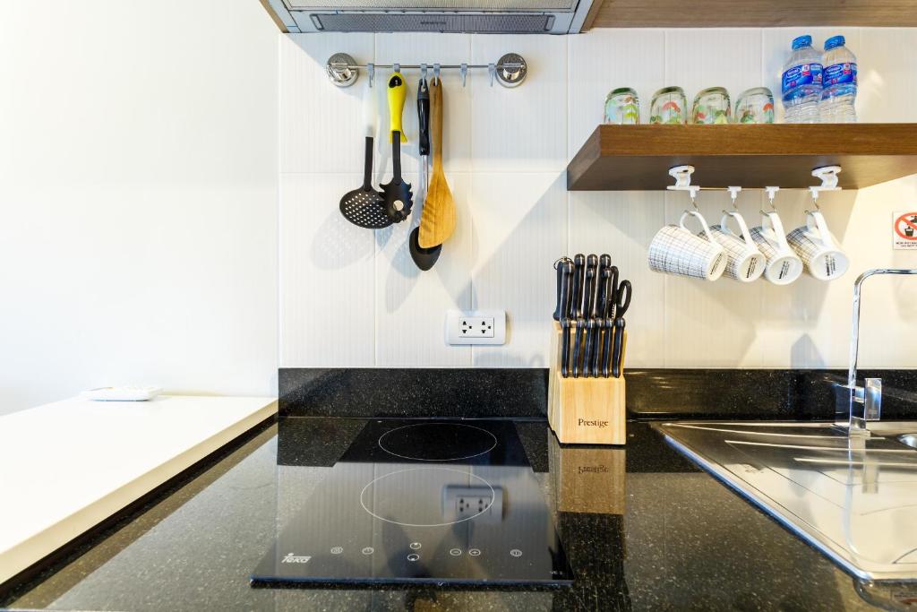 a kitchen with a counter with a sink and utensils at Apartments at The Bliss Condo by Lofty in Patong Beach