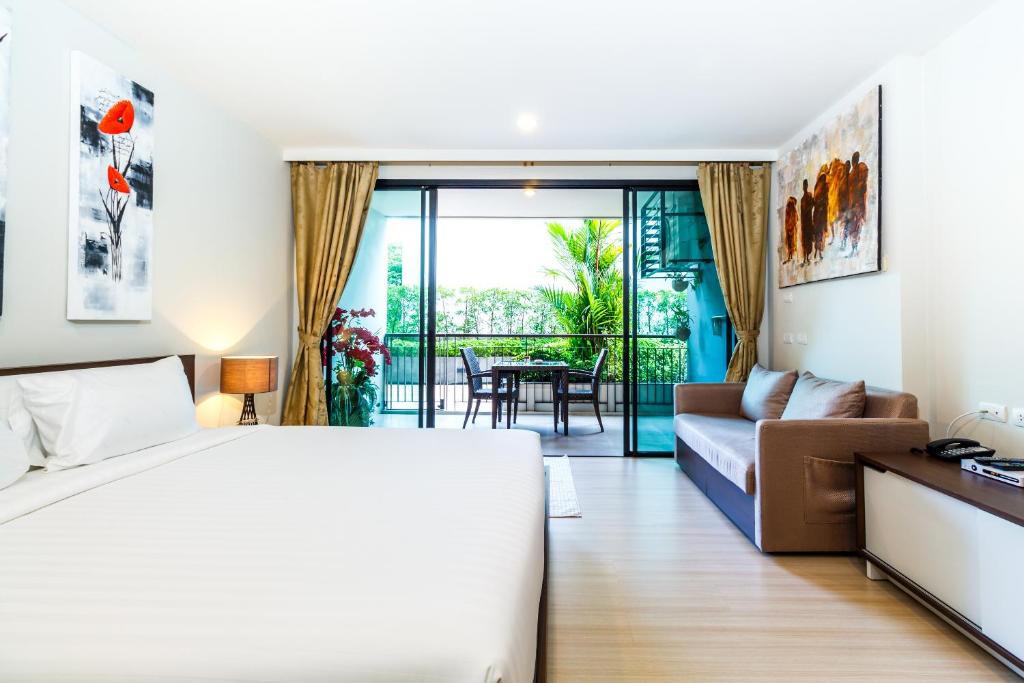 a bedroom with a bed and a couch and a table at Apartments at The Bliss Condo by Lofty in Patong Beach