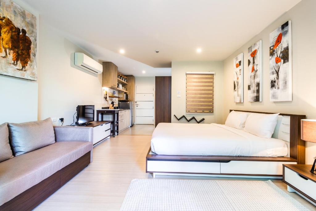 a bedroom with a bed and a couch at Apartments at The Bliss Condo by Lofty in Patong Beach