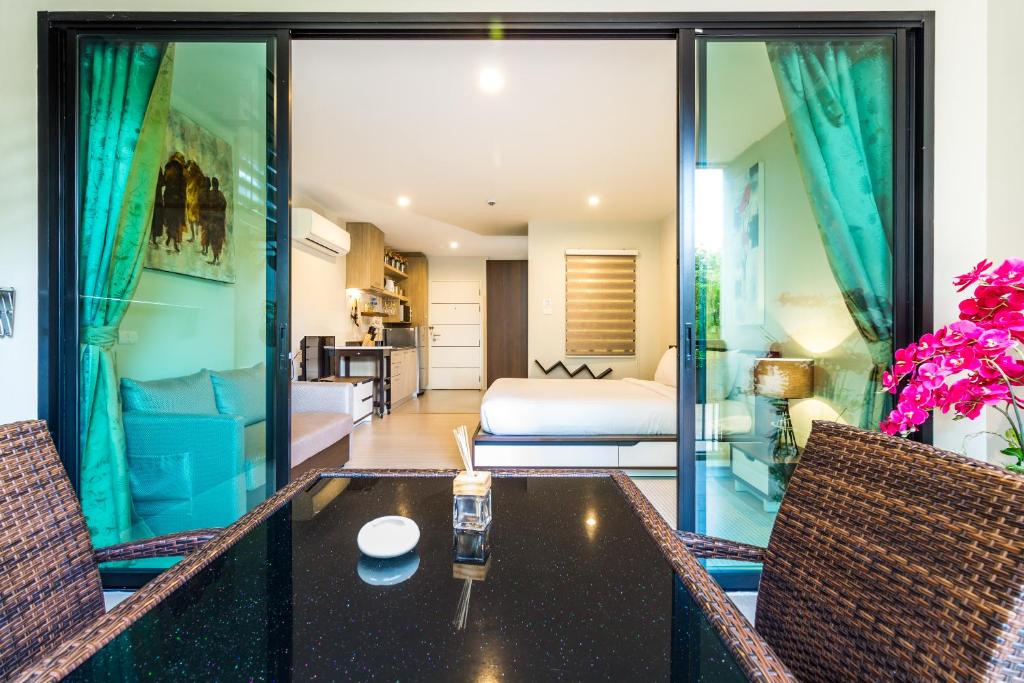 a room with a table and two chairs and a bedroom at Apartments at The Bliss Condo by Lofty in Patong Beach