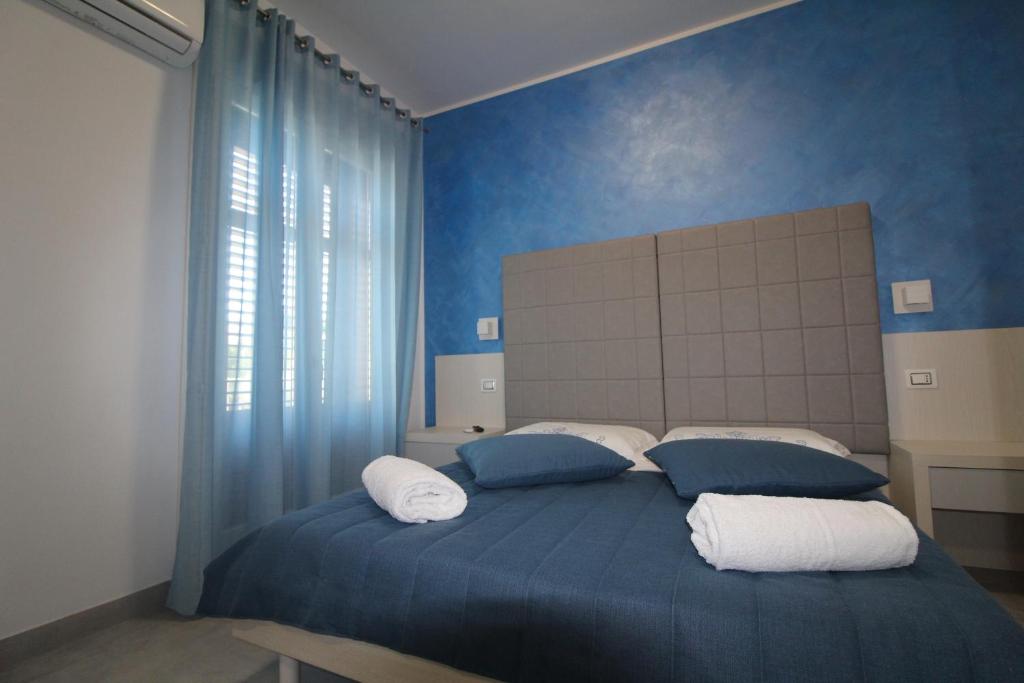 a blue bedroom with a bed with two pillows at B&B Villa Bea in San Vito lo Capo