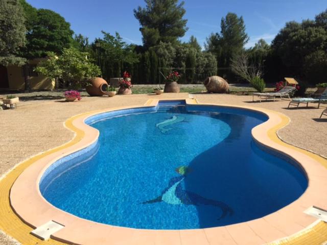 una gran piscina de agua azul en un patio en Villa Rural Paquete en Pozo Alcón