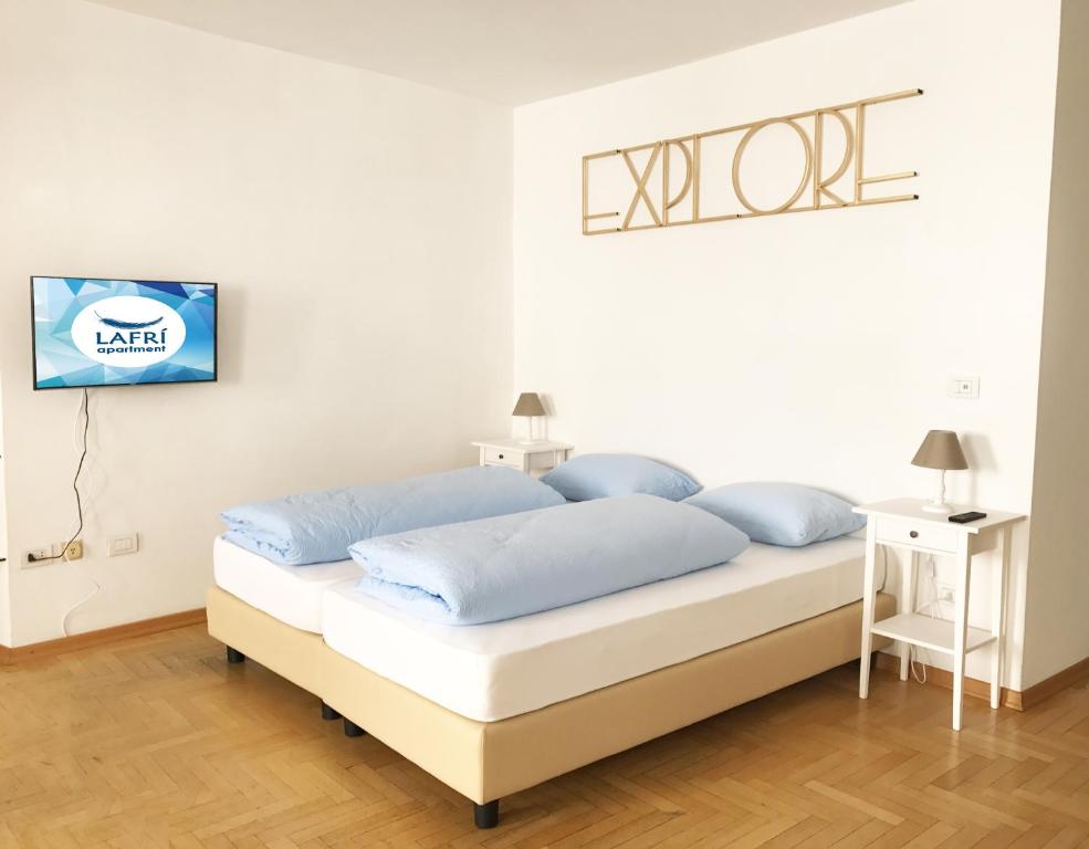 una camera da letto con un letto con cuscini blu di Lafri Apartment a Bolzano
