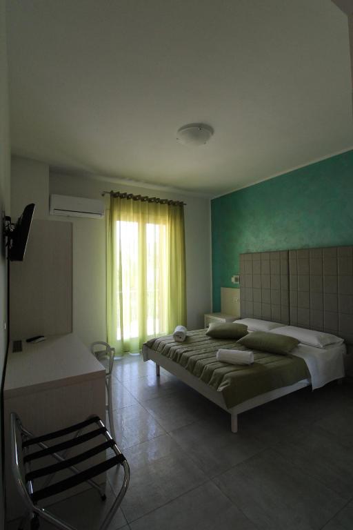 a bedroom with a large bed and a window at B&B Villa Bea in San Vito lo Capo
