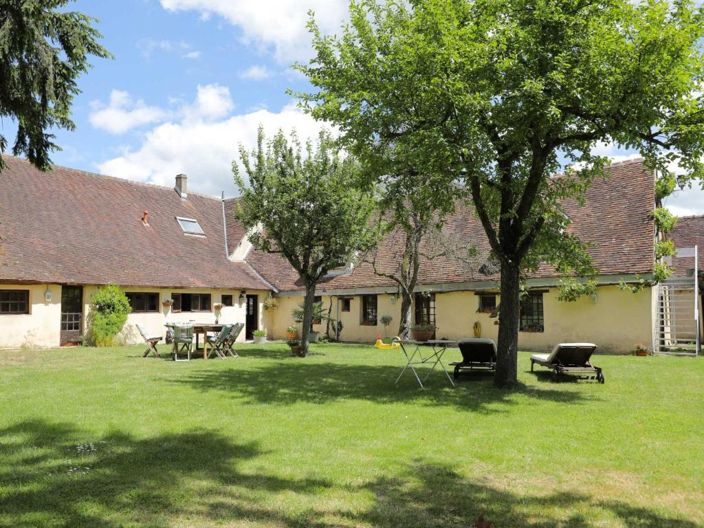 a house with a yard with tables and chairs at La Vigne in Saint-Jean-de-Rebervilliers