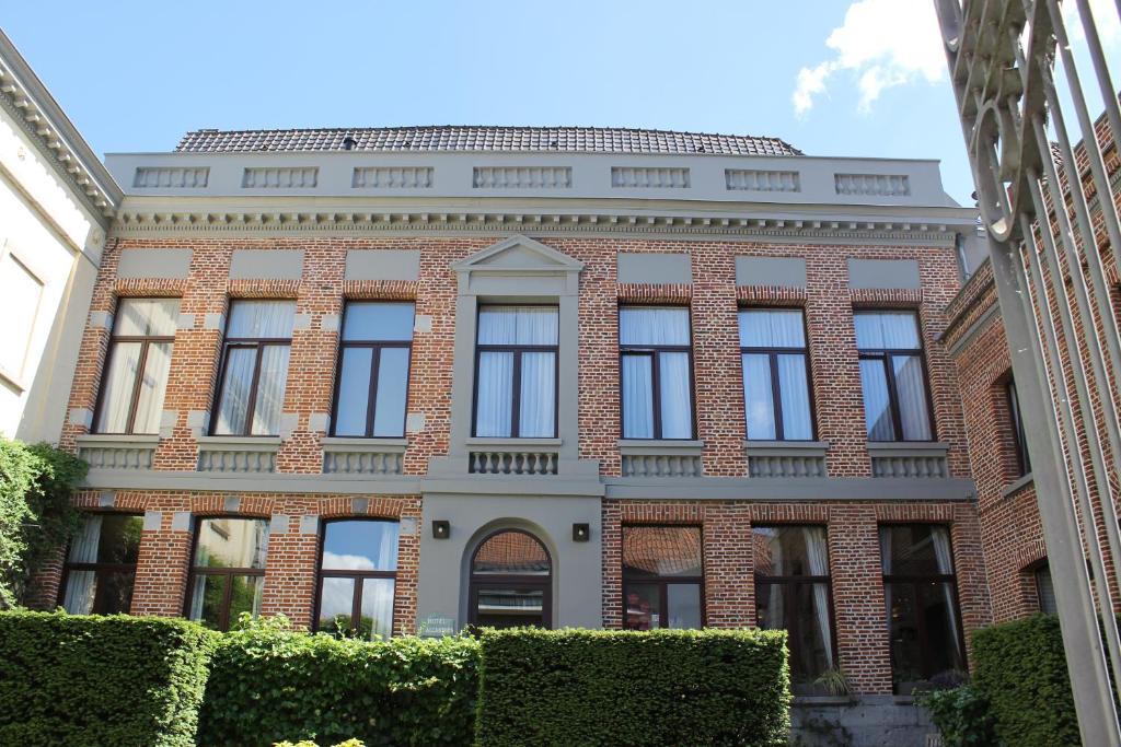 a red brick building with black windows at Hotel d'Alcantara in Tournai