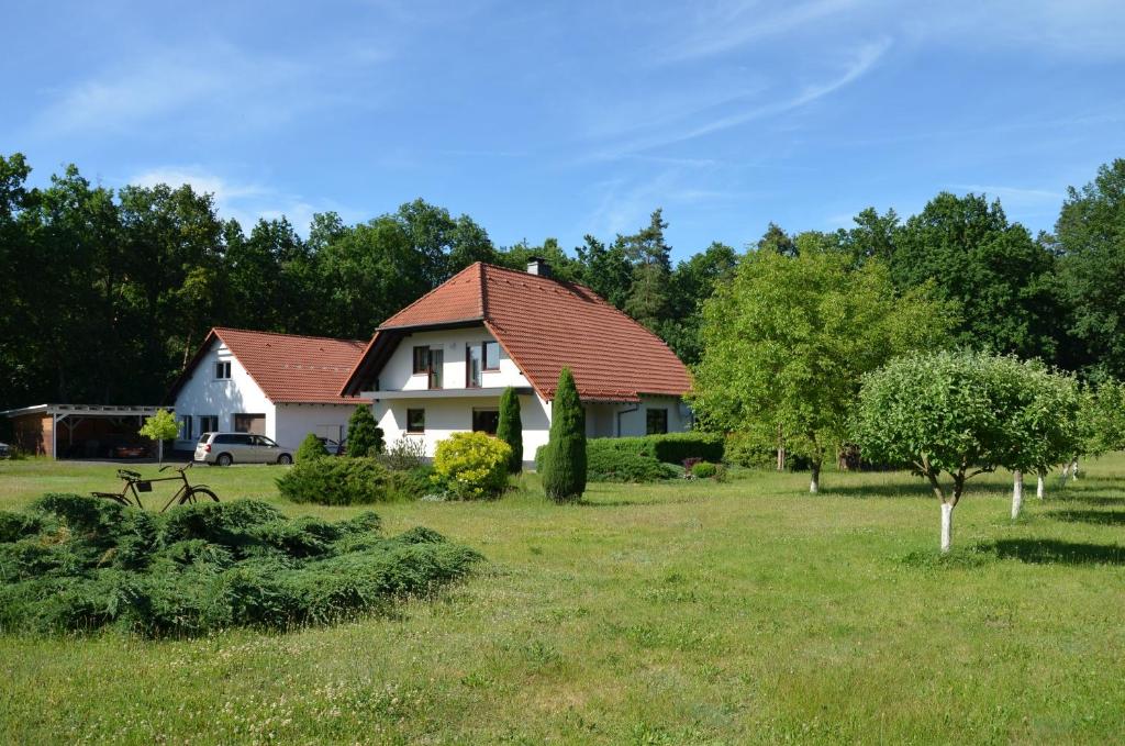 a white house with a red roof in a field at Kwatery przy A4 in Dąbrowa Bolesławiecka