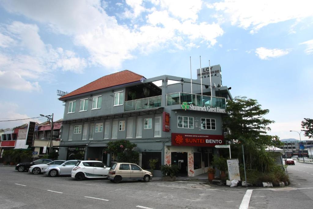 a large building with cars parked in front of it at Shamrock Guest House in Ipoh