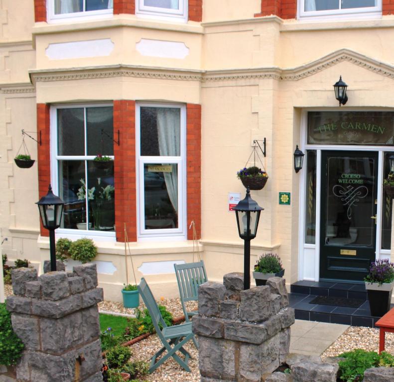 a building with a bench in front of a store at The Carmen Guesthouse in Llandudno