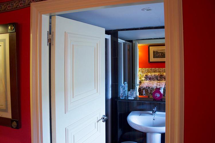 bagno con lavandino e specchio di Hotel la Fundacion a Bretún
