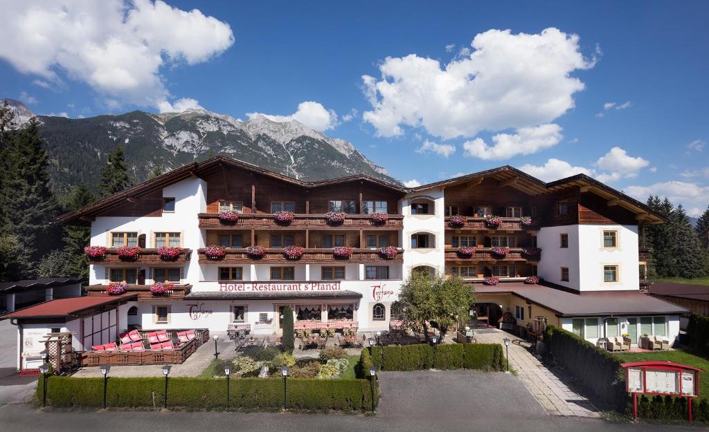a large hotel with mountains in the background at Bergidyll & Hotel Trofana in Leutasch