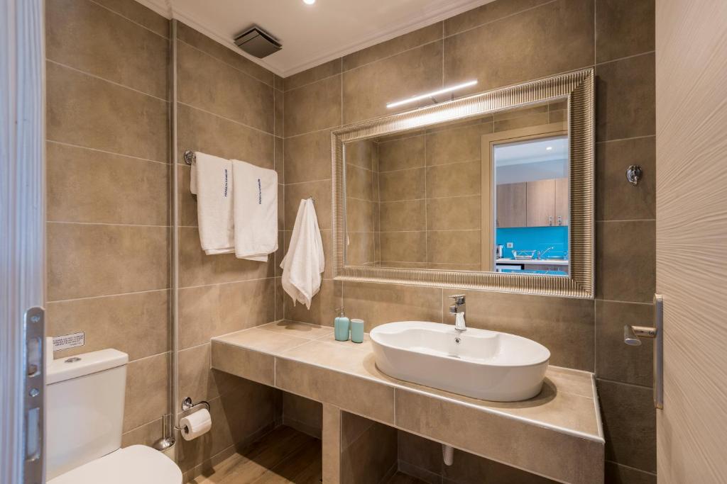 a bathroom with a sink and a toilet and a mirror at Pansion Ermioni in Skala