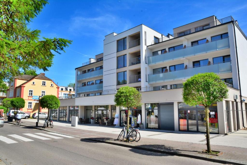 a white building on a city street with trees at DW Koral in Niechorze