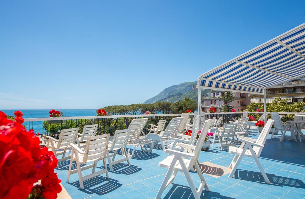 a row of white chairs sitting on a patio at La Residenza Aparthotel in Maiori