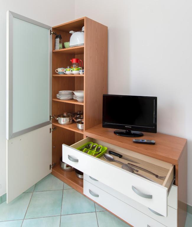 a living room with a tv and a cabinet at La Residenza Aparthotel in Maiori