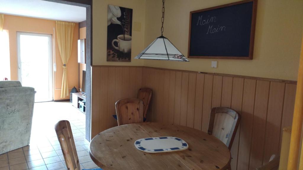 a dining room with a wooden table and chairs at Haus Spitzenblick in Friedrichskoog