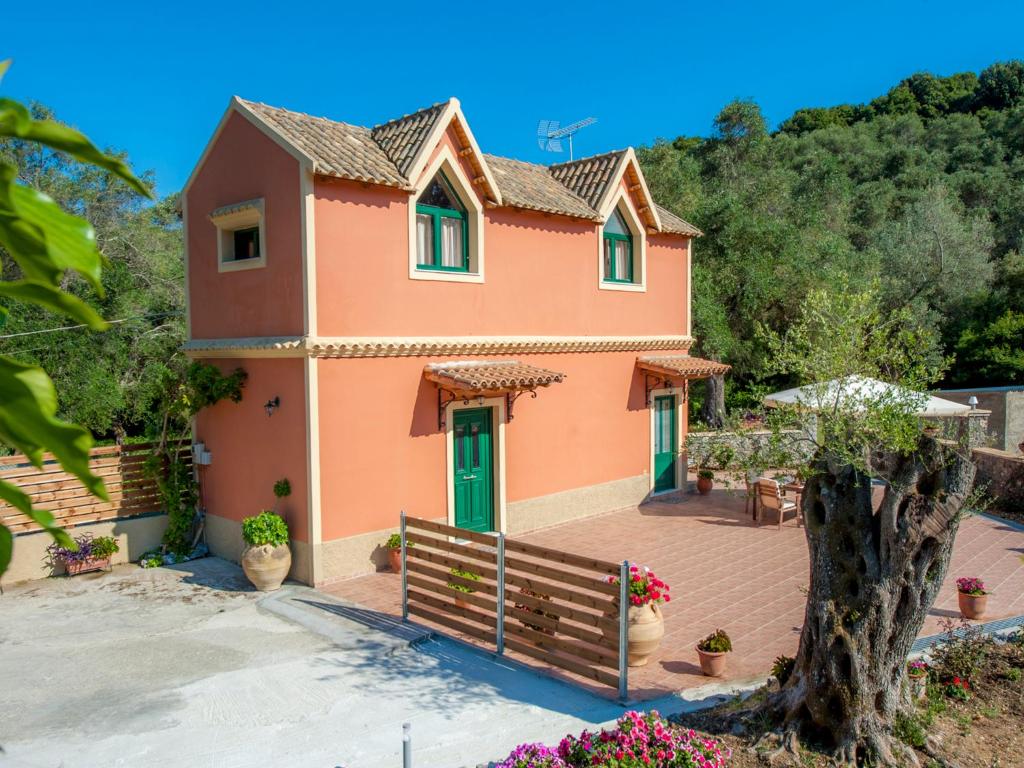 a house with a green door and a fence at Pieros Studios Lisipios in Paleokastritsa