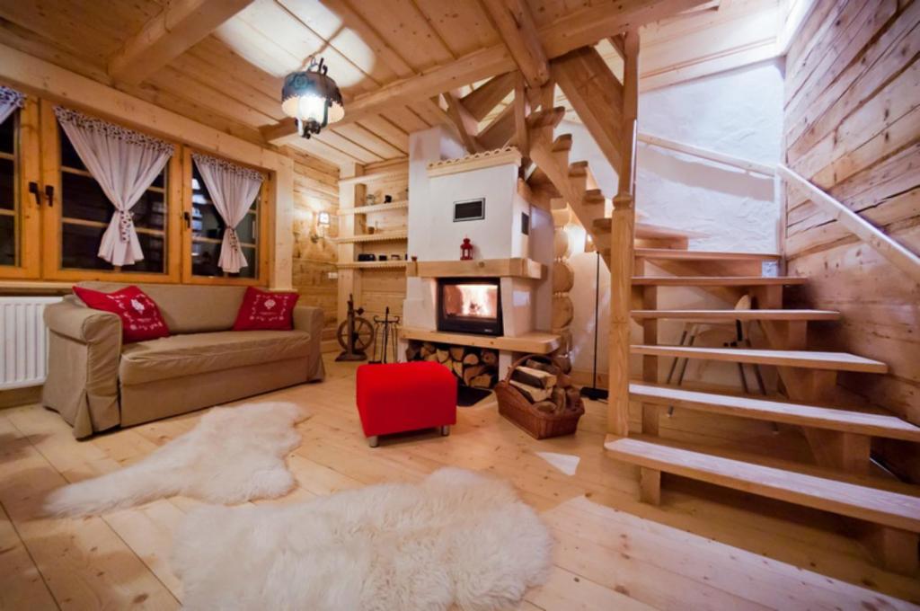 a living room with a couch and a fireplace at Wooden Tatra House in Zakopane