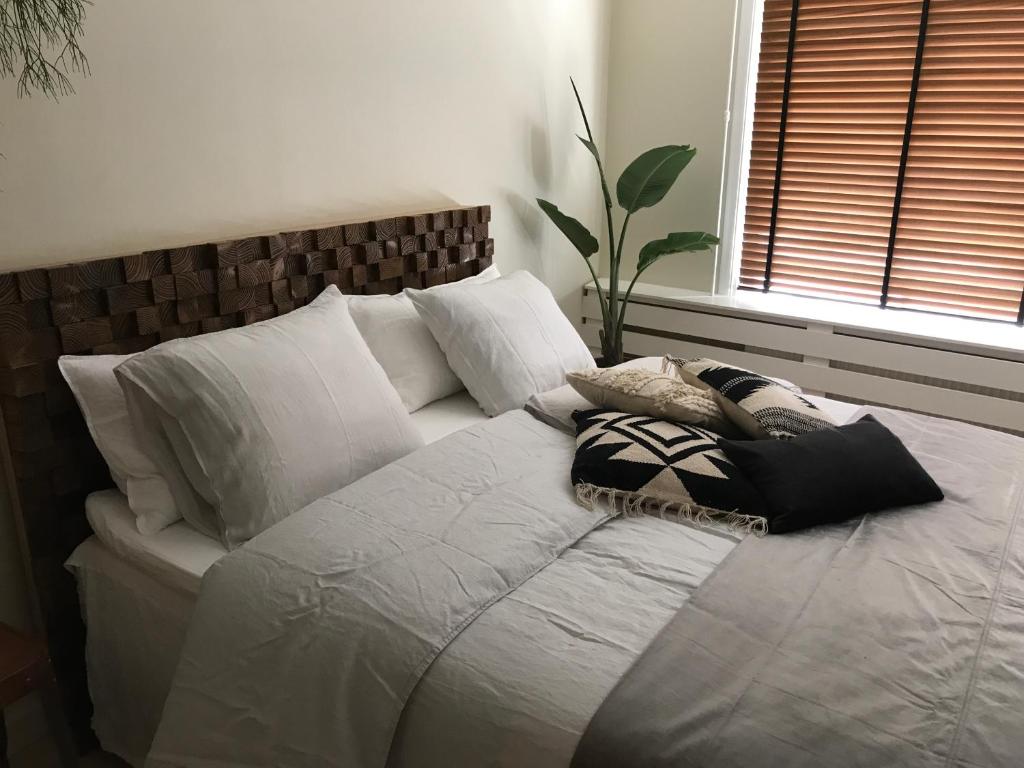 ミデルブルフにあるbednextdoorの白いベッド(枕付)が備わるベッドルームです。