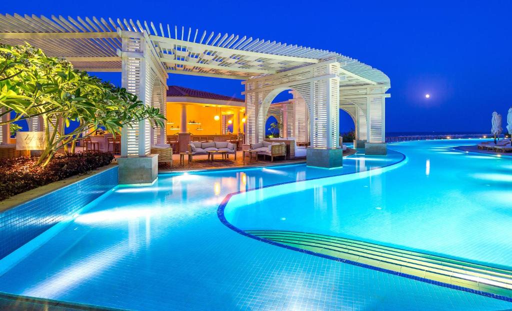 a swimming pool in a resort at night at Baron Palace Sahl Hasheesh in Hurghada