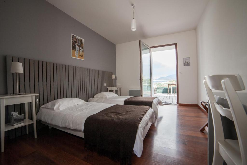 a hotel room with two beds and a window at Hôtel Restaurant Aldaburua in Larressore
