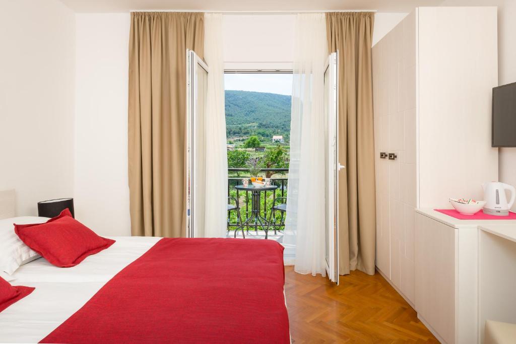 um quarto de hotel com uma cama com um cobertor vermelho em B&B Aurora em Jelsa