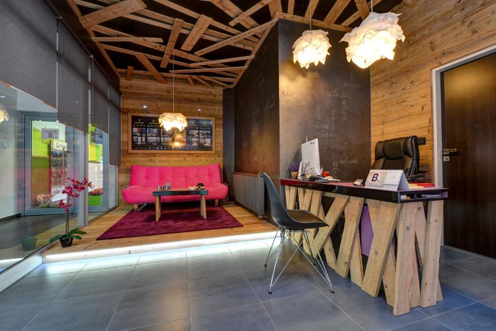 una oficina con sofá rosa y escritorio en Apartmány ELISA, en Šumperk