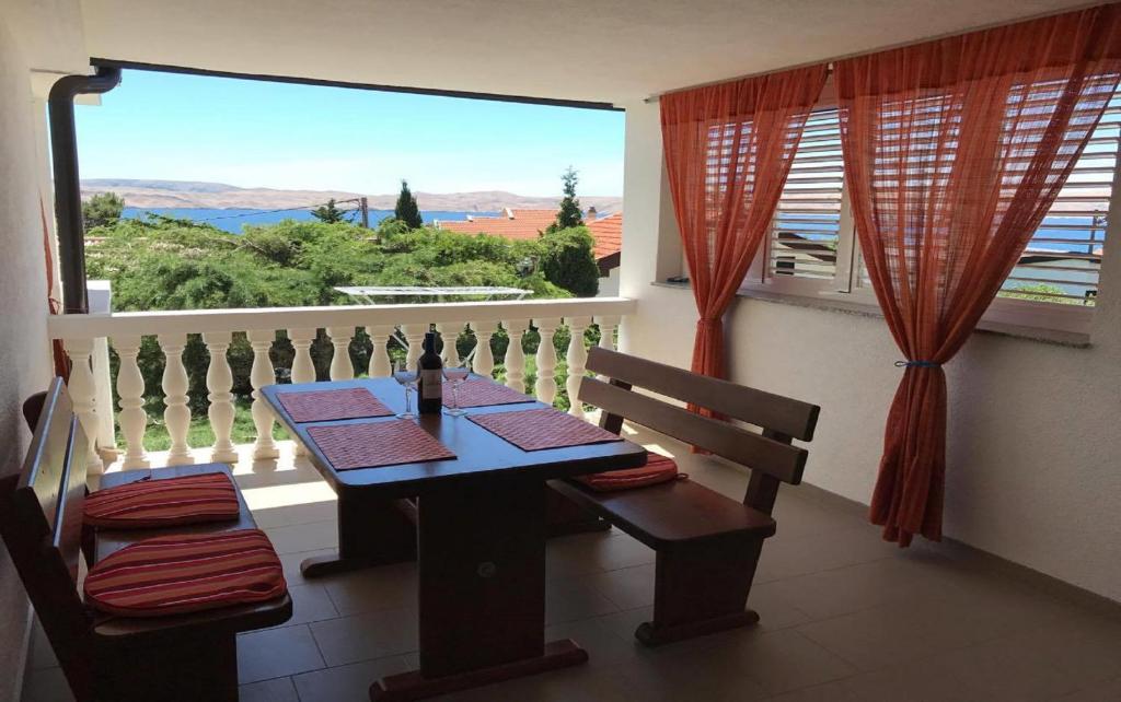 a dining room with a table and a large window at 35 meters from sea Apartment Keser and House for rent in Karlobag