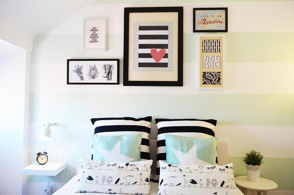 a bedroom with a bed with pillows and pictures on the wall at Belém Apartment in Lisbon