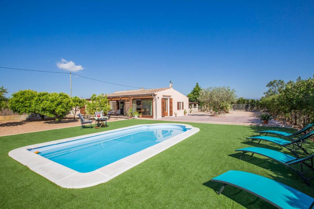 een zwembad in een tuin met stoelen en een huis bij Shostalet in Montuiri