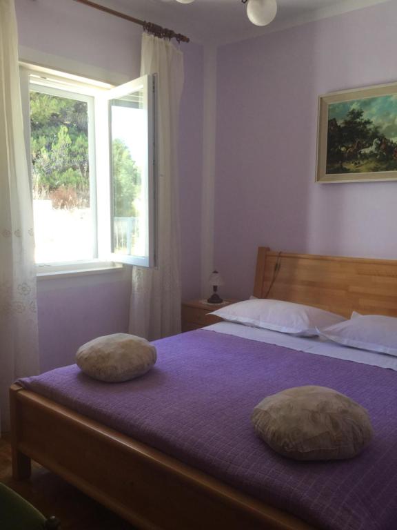 - une chambre avec 2 oreillers sur un lit et une fenêtre dans l'établissement Apartment Marija, à Primošten