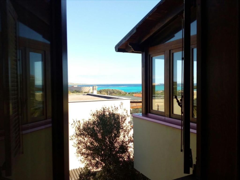 an open window with a view of the ocean at Casa La Pelosa in Stintino