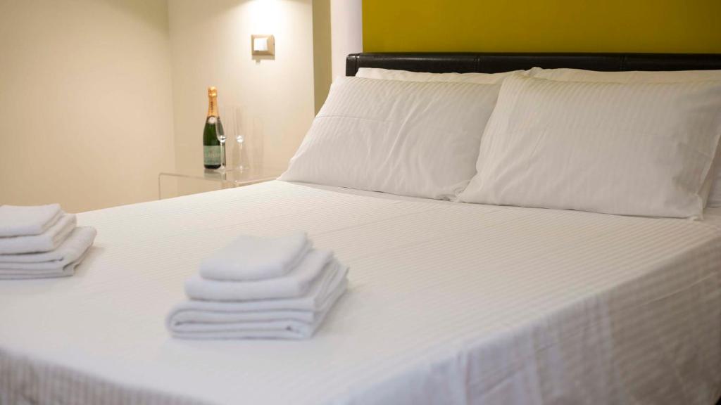 a bed with towels on it with a bottle of wine at Al centro di Roma in Rome